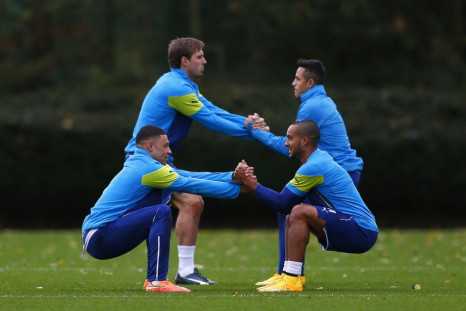 Arsenal players (L-R) Alex Oxlade-Chamberlain, Nacho Monreal,Theo Walcott and Alexis Sanchez warm up during a training session at their training facility in London Colney, north of London, November 3, 2014. Arsenal are due to play Anderlecht in a Champion