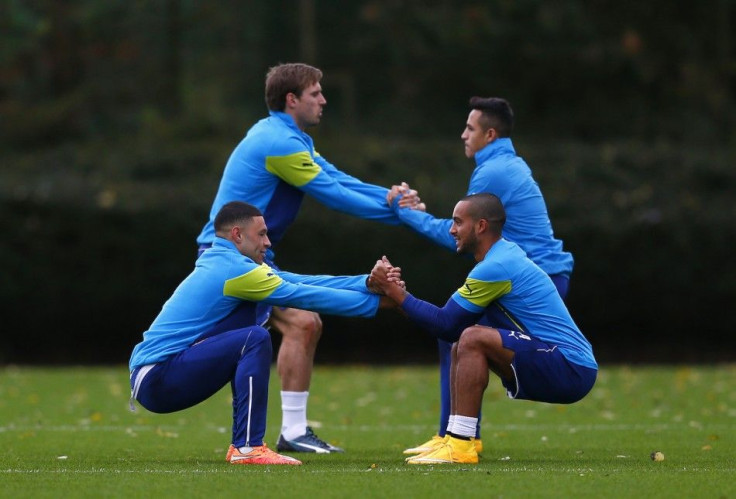 Arsenal players (L-R) Alex Oxlade-Chamberlain, Nacho Monreal,Theo Walcott and Alexis Sanchez warm up during a training session at their training facility in London Colney, north of London, November 3, 2014. Arsenal are due to play Anderlecht in a Champion