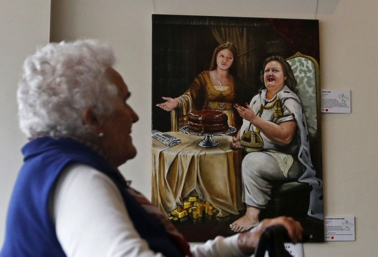 A woman looks at the painting 'The Banquet of Gina and Ginia' by artist Warren Lane at the Bald Archy Prize exhibition in Sydney April 6, 2013. The portrait depicting Australia's iron ore magnate Gina Rinehart eating a chocolate cake as her daughter Ginia