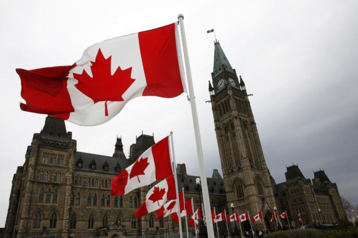 Canadian flags line the road around Parliament Hill during the National Day of Honour ceremony in Ottawa May 9, 2014. The event marks the end of Canada's military mission in Afghanistan. REUTERS/Blair Gable