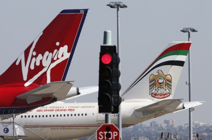 Virgin and Etihad planes are parked next to each other at Kingsford Smith airport in Sydney August 30, 2013. Virgin Australia Holdings Ltd reported a A$98.1 million ($87.6 million) full-year net loss on Friday, blaming difficult economic conditions, stron