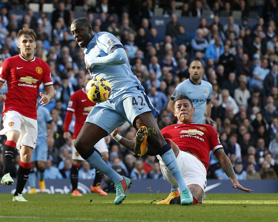 Manchester Citys Yaya Toure C is challenged by Manchester Uniteds Marcos Rojo during their English Premier League soccer match at the Etihad Stadium in Manchester, northern England November 2, 2014. 