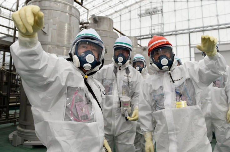 Japan's new Economy, Trade and Industry Minister Yoichi Miyazawa (R), wearing a protective suit and a mask, inspects the Tokyo Electric Power Co. (TEPCO)'s tsunami-crippled Fukushima Daiichi nuclear power plant in Fukushima prefecture, in this p
