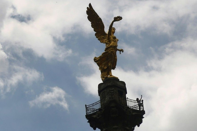 A woman takes a selfie on top of the Angel de la Independencia monument in Mexico City, September 26, 2014.