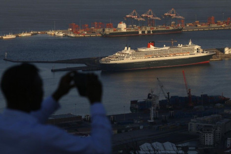 A visitor takes photographs of Cunard's cruise liner Queen Mary 2 as the ship sits berthed in Cape Town harbour in this picture taken January 27, 2014.