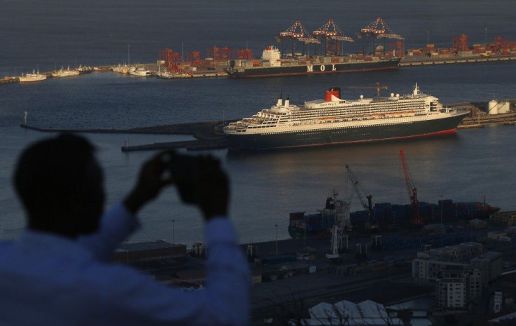 A visitor takes photographs of Cunard's cruise liner Queen Mary 2 as the ship sits berthed in Cape Town harbour in this picture taken January 27, 2014.