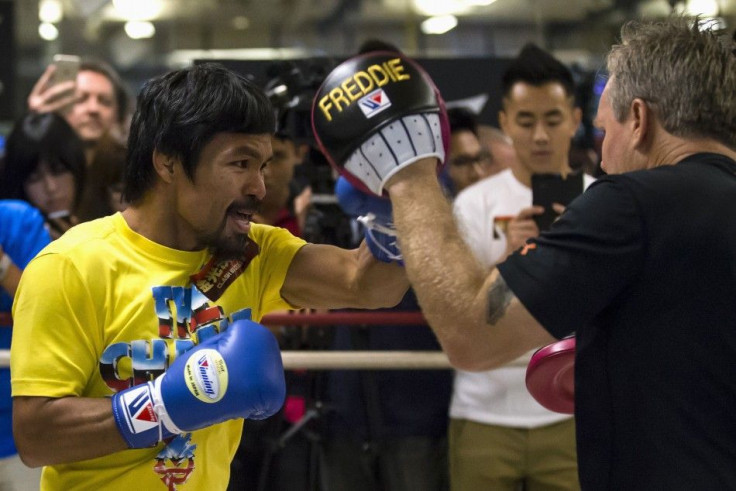 Boxer Manny Pacquiao of the Philippines practices with trainer Freddie Roach (R) during a media workout in Hong Kong