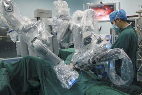 A doctor operates on a patient with a surgical robot in Hefei, Anhui province September 24, 2014. Technology is playing a growing role as Beijing overhauls a healthcare management sector blighted by chaotic patient data, underfunded rural health centres, 