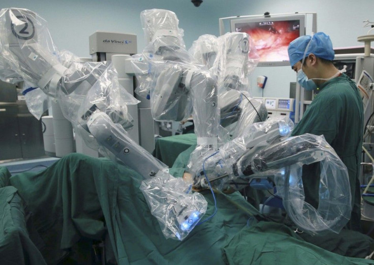 A doctor operates on a patient with a surgical robot in Hefei, Anhui province September 24, 2014. Technology is playing a growing role as Beijing overhauls a healthcare management sector blighted by chaotic patient data, underfunded rural health centres, 