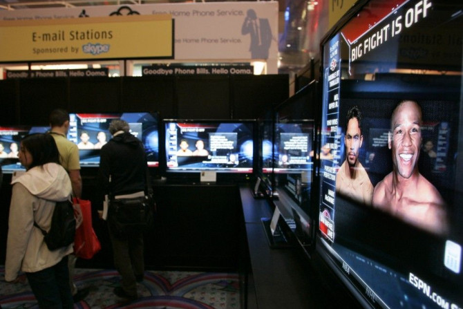 Show-goers watch ESPN reports on the boxing match between Manny Pacquiao of the Philippines and Floyd Mayweather Jr. of the U.S. at the 2010 International Consumer Electronics Show (CES) in Las Vegas, Nevada January 7, 2010.