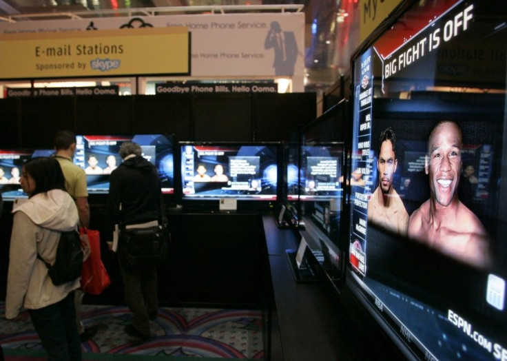 Show-goers watch ESPN reports on the boxing match between Manny Pacquiao of the Philippines and Floyd Mayweather Jr. of the U.S. at the 2010 International Consumer Electronics Show (CES) in Las Vegas, Nevada January 7, 2010.