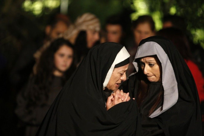 Actresses portraying Mary (L) and Mary Magdalene (R) take part in the interactive street-theatre performance of Il-Mixja (The Way) in Attard, outside Valletta, April 16, 2014. The Passion play was held in the grounds of Mount Carmel Mental Hospital as par