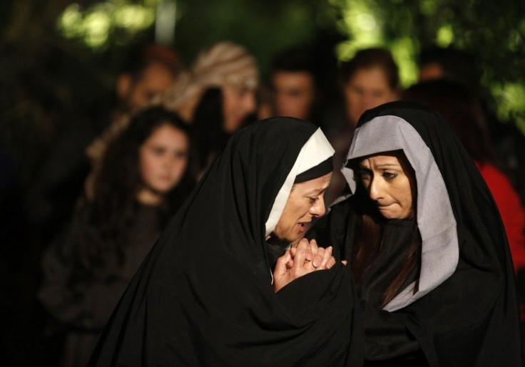 Actresses portraying Mary (L) and Mary Magdalene (R) take part in the interactive street-theatre performance of Il-Mixja (The Way) in Attard, outside Valletta, April 16, 2014. The Passion play was held in the grounds of Mount Carmel Mental Hospital as par