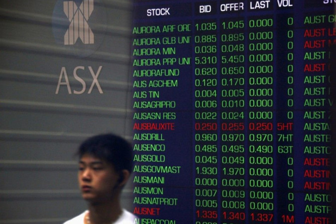 A pedestrian is reflected in the window of the Australian Securities Exchange with boards displaying stock movements, in central Sydney September 24, 2014. Australian shares lost 0.7 percent on Wednesday morning as Wall Street fell overnight for a third s