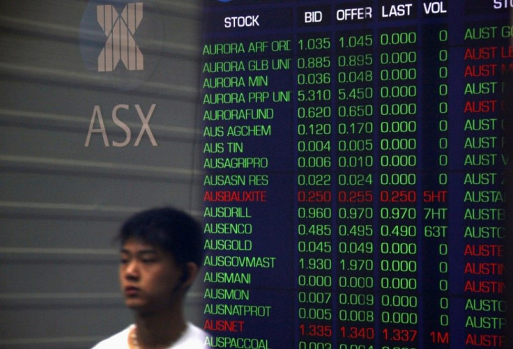 A pedestrian is reflected in the window of the Australian Securities Exchange with boards displaying stock movements, in central Sydney September 24, 2014. Australian shares lost 0.7 percent on Wednesday morning as Wall Street fell overnight for a third s