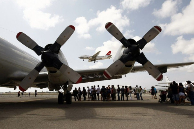 An Air Malta plane prepares to land as visitors queue to board a U.S. Navy Lockheed P-3C Orion maritime surveillance aircraft during the Malta Airshow at Malta International Airport outside Valletta September 25, 2011. REUTERS/Darrin Zammit Lupi