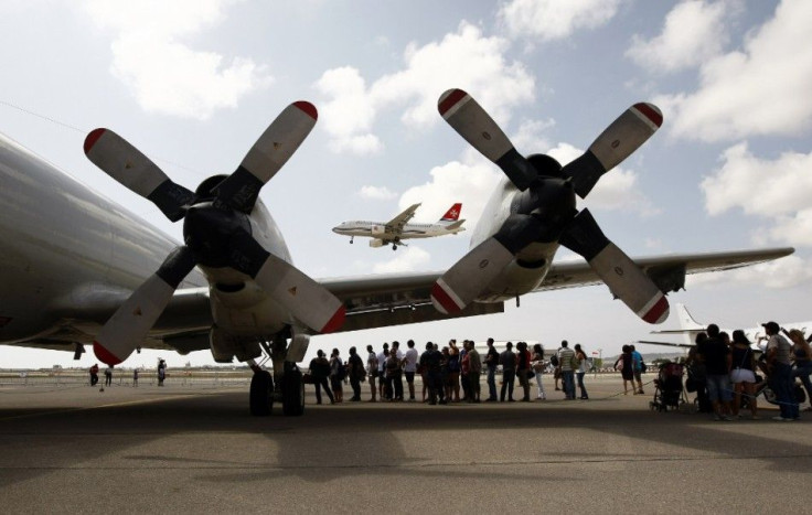 An Air Malta plane prepares to land as visitors queue to board a U.S. Navy Lockheed P-3C Orion maritime surveillance aircraft during the Malta Airshow at Malta International Airport outside Valletta September 25, 2011. REUTERS/Darrin Zammit Lupi