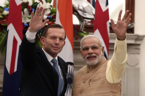 Australia&#039;s Prime Minister Tony Abbott (L) and his Indian counterpart Narendra Modi wave toward the media after a signing of agreements ceremony in New Delhi
