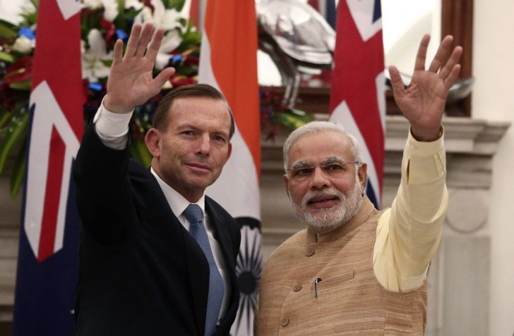 Australia&#039;s Prime Minister Tony Abbott (L) and his Indian counterpart Narendra Modi wave toward the media after a signing of agreements ceremony in New Delhi