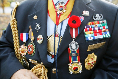 Charles Kim with the Korean Veterans Association Canada chapter, shows military honors at an annual ribbon tying ceremony