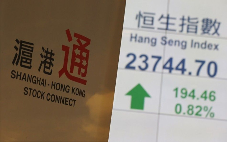 A banner introducing the Shanghai-Hong Kong Stock Connect is displayed in front of a panel showing the closing blue-chip Hang Seng Index at the Hong Kong Stock Exchange in Hong Kong November 10, 2014. Hong Kong and Shanghai will link their stock exchanges