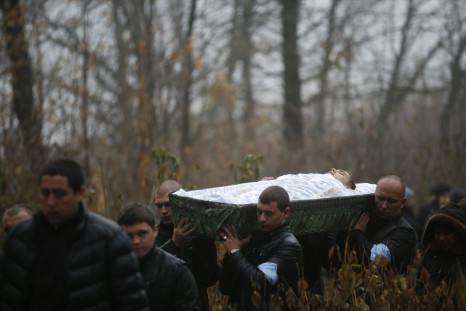 People carry a coffin with the body of Andrei Eliseev during a funeral ceremony in the village of Hrabary (Grabari) in Donetsk, eastern Ukraine, November 7, 2014. Eliseev was one of two teenagers killed by shelling while out playing on a school sports fie