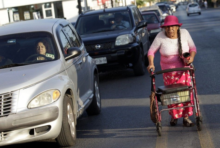 Maria Josefina Perez, 81, uses a wheelchair as a walker as she begs from passing drivers in Monterrey August 15, 2014.