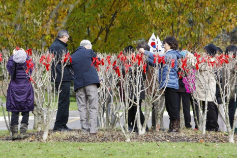 Members of the Rose of Sharon Association of Toronto tie ribbons on Rose of Sharon trees in honor of 516 Canadian troops who lost their lives in the Korean War (1950-1953) at an annual ribbon tying ceremony at the Rose of Sharon Garden in James Gardens in
