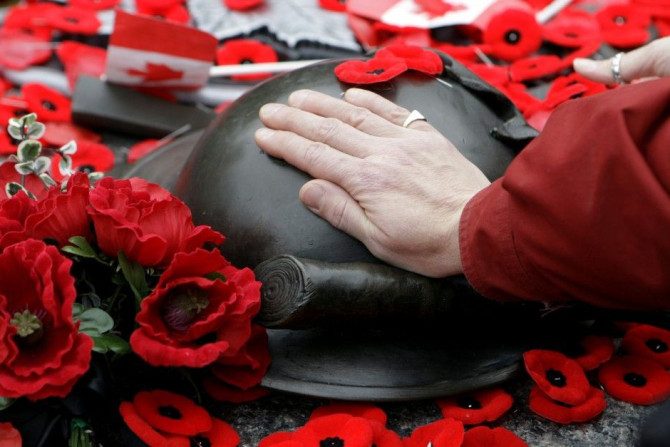 A woman places her hand on the Tomb of the Unknown Soldier following Remembrance Day ceremonies
