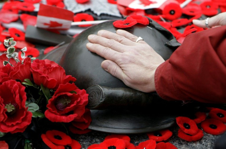 A woman places her hand on the Tomb of the Unknown Soldier following Remembrance Day ceremonies