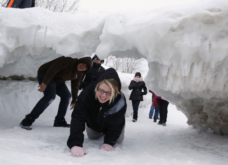 Sightseers make their way under an arch formed by shove ice piling up on the shores of Lake Erie, in Crystal Beach, Ontario February 17, 2014. A cool autumn and early winter combined with polar vortexes helped lake ice build up weeks earlier than normal, 