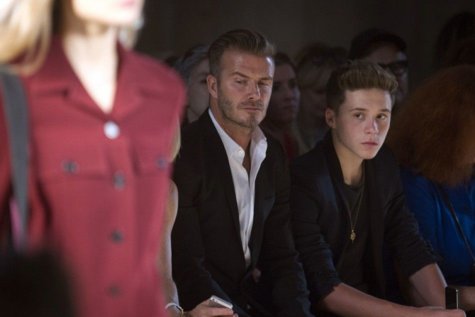 David Beckham and his son Brooklyn Beckham watch a model present a creation during the Victoria Beckham Spring/Summer 2015 collection during New York Fashion Week in the Manhattan borough of New York September 7, 2014.