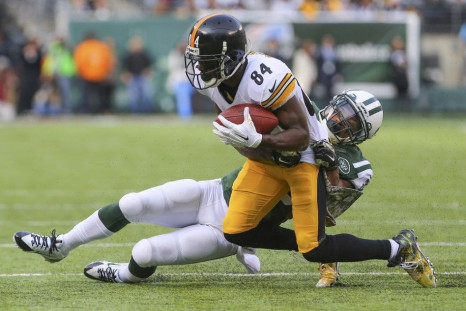 Pittsburgh Steelers wide receiver Antonio Brown (84) is tackled by New York Jets cornerback Kyle Wilson (20) after catching a pass during the first half at MetLife Stadium.