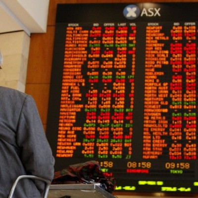 Men watch the stock board at the Australian Securities Exchange (ASX) in central Sydney April 21, 2009. Australian stocks fell 2.6 percent on Tuesday, led down by banks and miners, on fresh concerns about the earnings outlook for domestic companies and a 