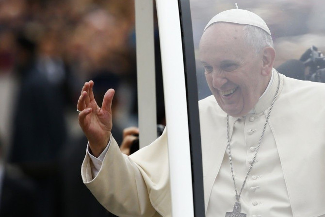 Pope Francis waves as he arrives to lead his weekly general audience in Saint Peter's Square at the Vatican.