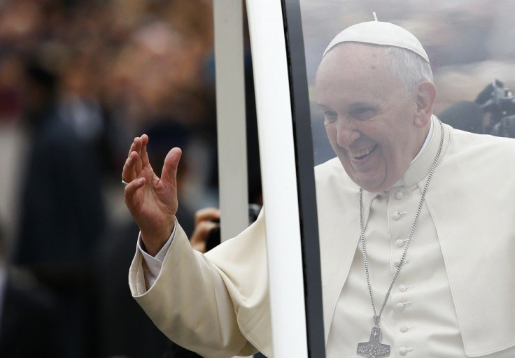 Pope Francis waves as he arrives to lead his weekly general audience in Saint Peter's Square at the Vatican.