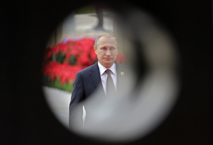 Russia&#039;s President Vladimir Putin is seen through a decoration as he walks on the red carpet upon arrival at the Asia Pacific Economic Cooperation (APEC) forum, at International Convention Center at Yanqi Lake in Beijing November 11, 2014. REUTERS/Ja