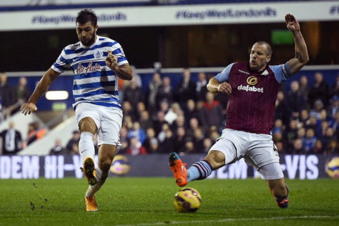 Queens Park Rangers' Charlie Austin (L) shoots past Aston Villa's Ron Vlaar to score his second goal during their English Premier League soccer match at Loftus Road in London, October 27, 2014.