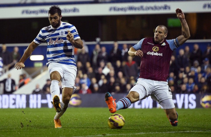 Queens Park Rangers' Charlie Austin (L) shoots past Aston Villa's Ron Vlaar to score his second goal during their English Premier League soccer match at Loftus Road in London, October 27, 2014.