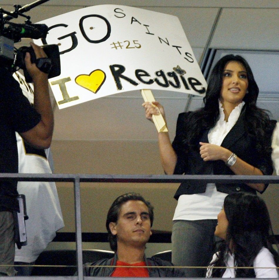Kim Kardashian L holds up a quotI Love Reggiequot sign