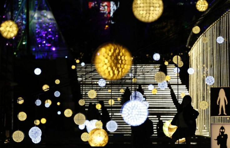 A woman poses for pictures in front of Christmas decorations outside Tokyo Dome in Tokyo November 7, 2014.