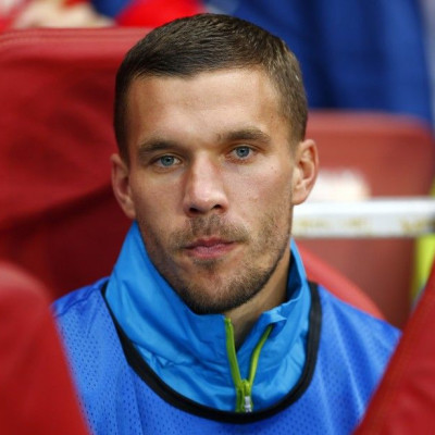 Arsenal's Lukas Podolski watches his team from the bench during their Champions League playoff soccer match against Besiktas at the Emirates stadium in London August 27, 2014.