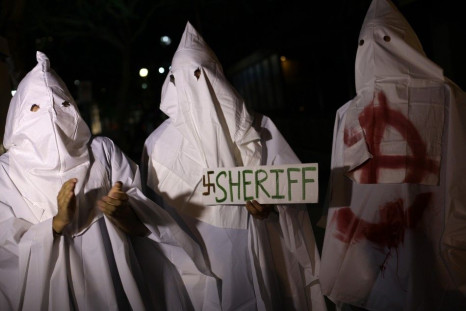 People dressed in Ku Klux Klan outfits poke fun at Maricopa County Sheriff Republican Joe Arpaio after his victory over Democratic challenger Paul Penzone to hold on to office as Maricopa County&#039;s sheriff, in Phoenix, Arizona November 7, 2012.