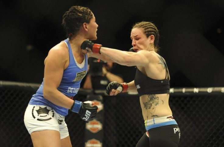 Feb 22, 2014; Las Vegas, NV, USA; Jessica Eye (blue gloves) lands a left hook on Alexis Davis (red gloves) during their UFC bantamweight bout at Mandalay Bay. Davis won the bout by split decision.