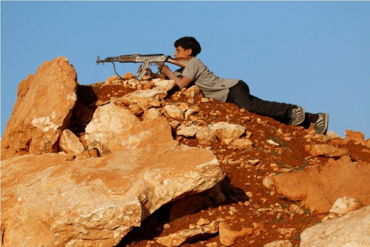 A rebel fighter aims his weapon as he takes a position on the frontline against Syria's President Bashar al-Assad's forces