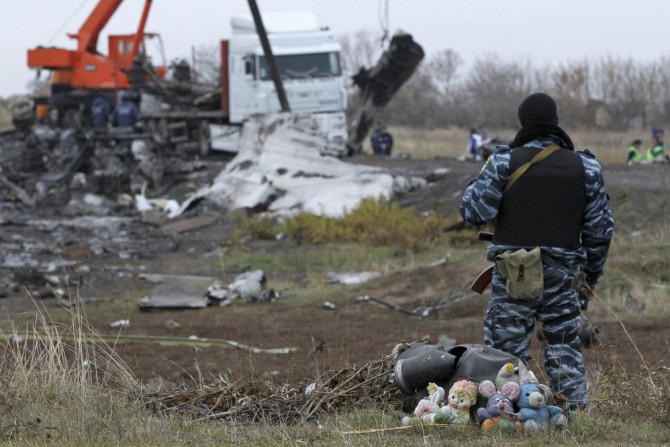 A pro-Russian armed man secures crash site wreckage of the Malaysia Airlines Boeing 777 plane (flight MH17) at the site of the plane crash near the settlement of Grabovo in the Donetsk region November 16, 2014. Local emergency services have begun collecti
