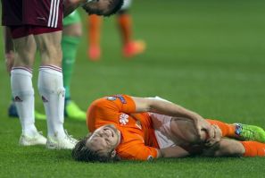 Daley Blind of the Netherlands lies injured after a challenge with Latvia's Eduards Viskanovs during their Euro 2016 Group A qualifying soccer match in Amsterdam November 16, 2014.