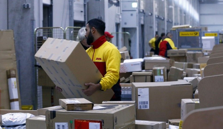 Workers load trucks with parcels at the new distribution centre of the German postal and logistics group Deutsche Post DHL in Berlin November 12, 2013. Deutsche Post posted a better-than-expected rise in quarterly operating profit as earnings at its domes