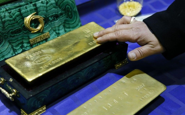 An employee displays a gold bar at a gold refining workshop of the plant of Uralelektromed Joint Stock Company (JSC), the enterprise of Ural Mining and Metallurgical company (UMMC) in the town of Verkhnyaya Pyshma, outside Yekaterinburg, October 17, 2014.
