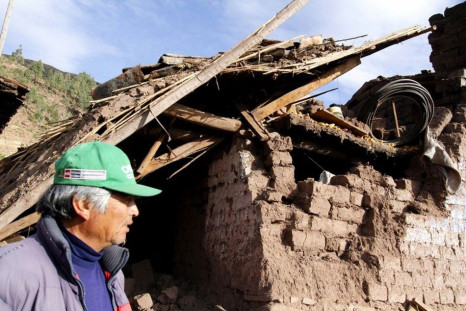 A man passes by the debris of a damaged house at a street in Paruro after a 5.1 magnitude earthquake hit Cuzco, September 28, 2014. At least eight people were killed by a 5.1 magnitude earthquake that hit rural southern Peru over the weekend, emergency au